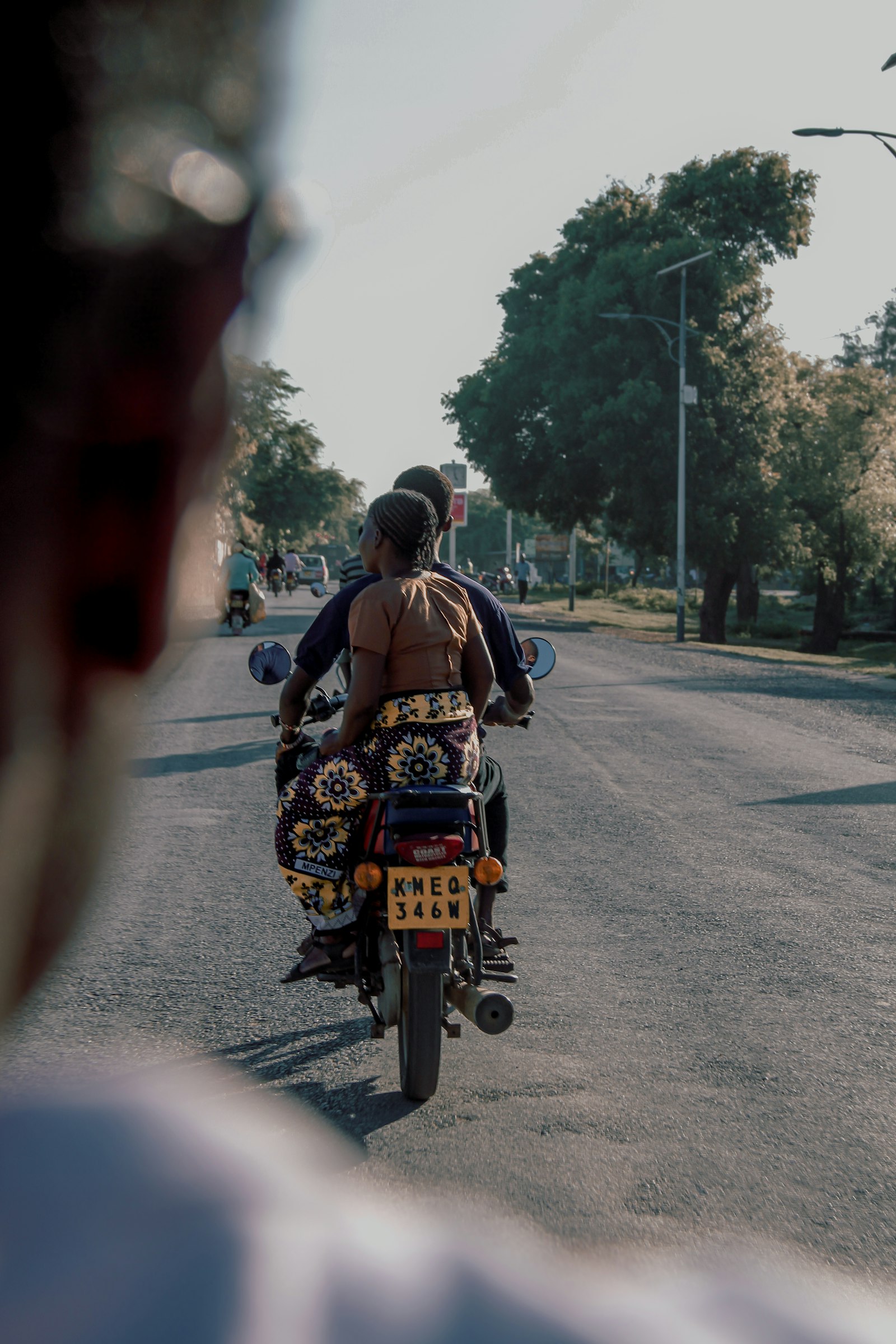 A motorbike rider carrying a passenger through the city